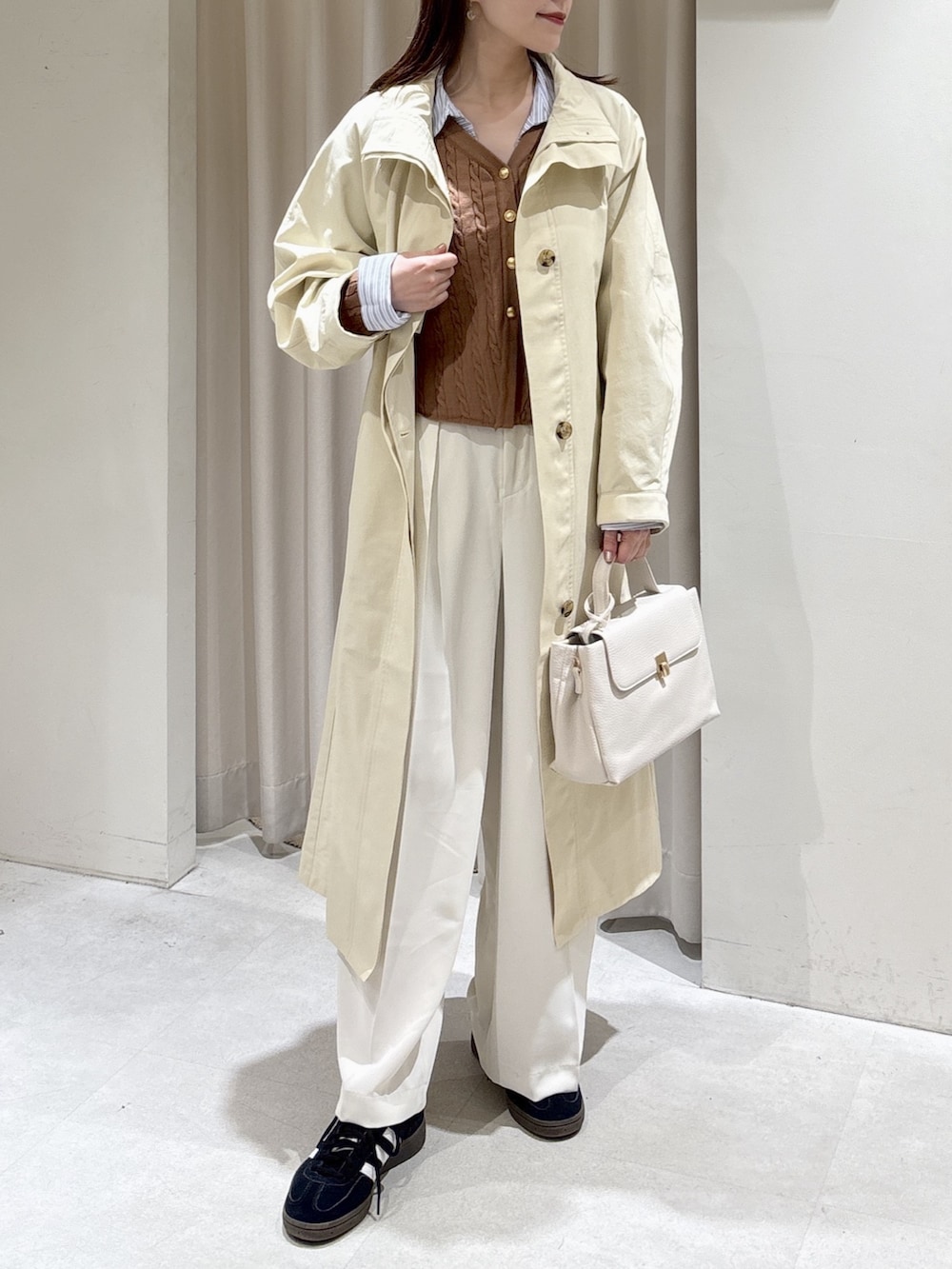 ベージュ系のニット/セーター、ホワイト系のスラックス、ホワイト系のショルダーバッグを着用したレディースの冬コーディネートの5枚目の写真