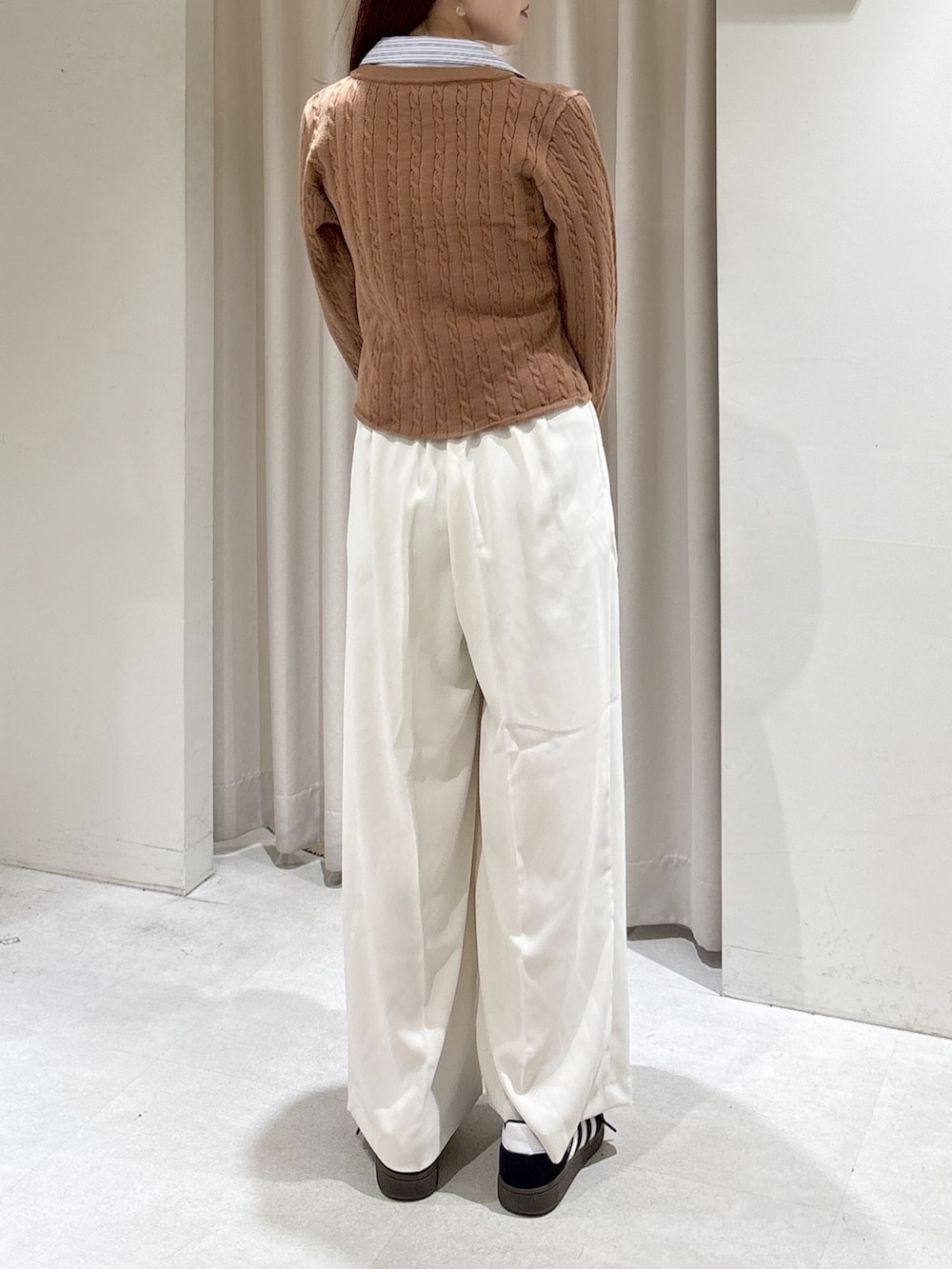 ベージュ系のニット/セーター、ホワイト系のスラックス、ホワイト系のショルダーバッグを着用したレディースの冬コーディネートの3枚目の写真