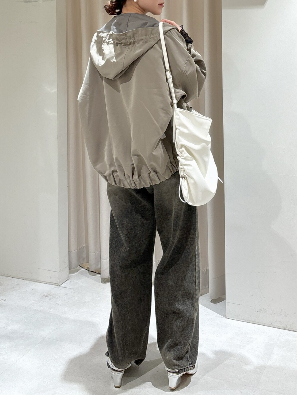 グリーン系のマウンテンパーカー、ブラック系のTシャツ/カットソー、ホワイト系のキャミソールを着用したレディースの冬コーディネートの10枚目の写真