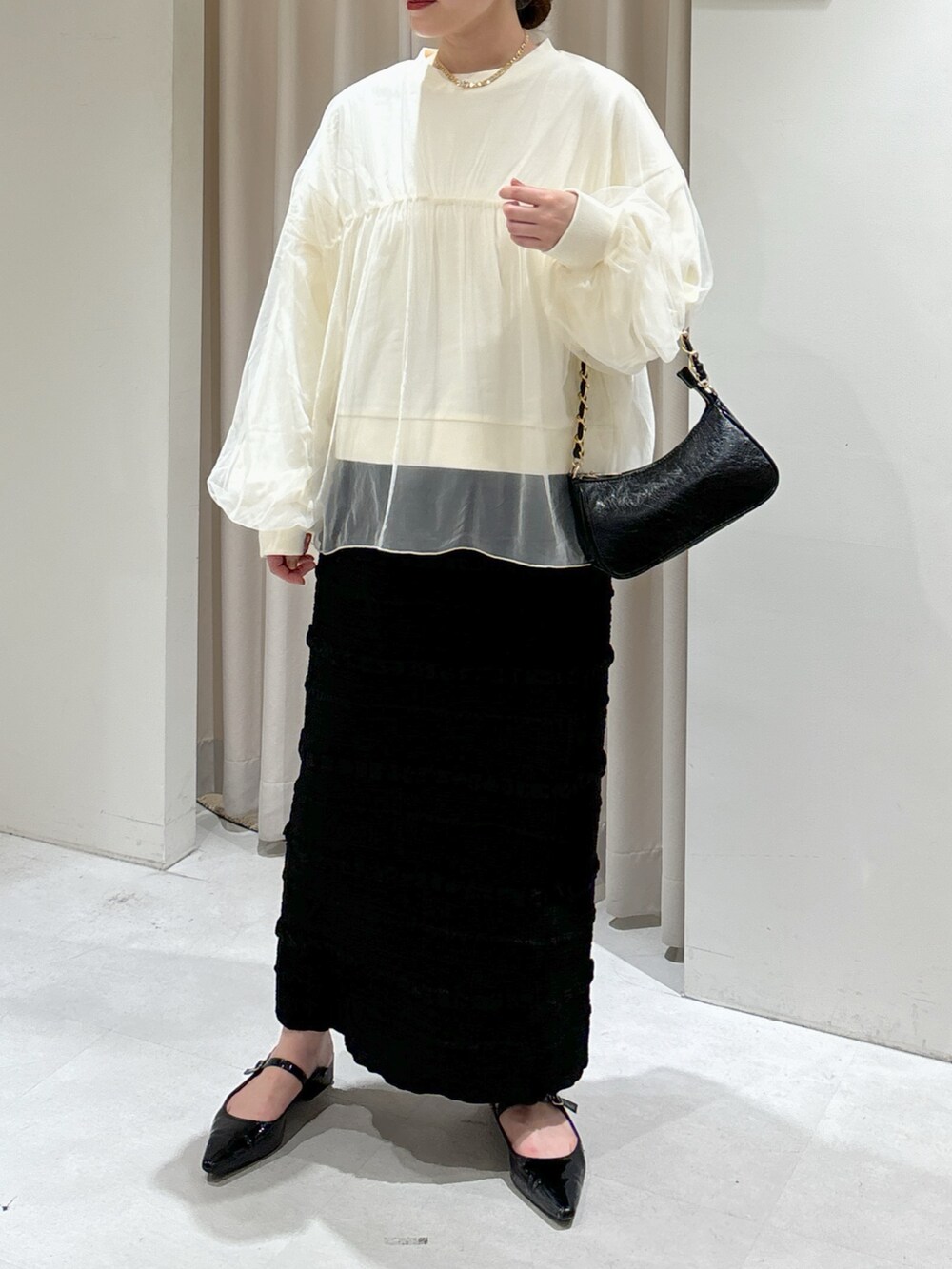 ホワイト系のスウェット、ブラック系のスカート、ブラック系のトートバッグを着用したレディースの秋コーディネートの6枚目の写真