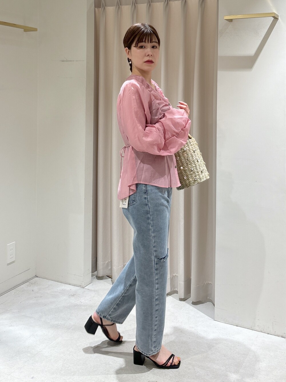 ピンク系のシャツ/ブラウス、イエロー系のかごバッグ、ブルー系のデニムパンツを着用したレディースの春コーディネートの2枚目の写真