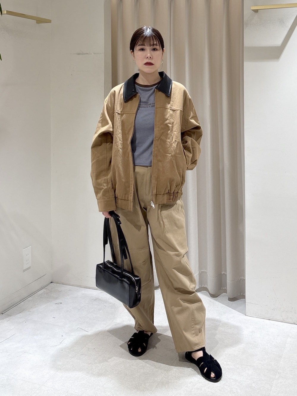 ブルー系のTシャツ/カットソー、ベージュ系のその他パンツ、ブラック系のショルダーバッグを着用したレディースの春コーディネートの2枚目の写真