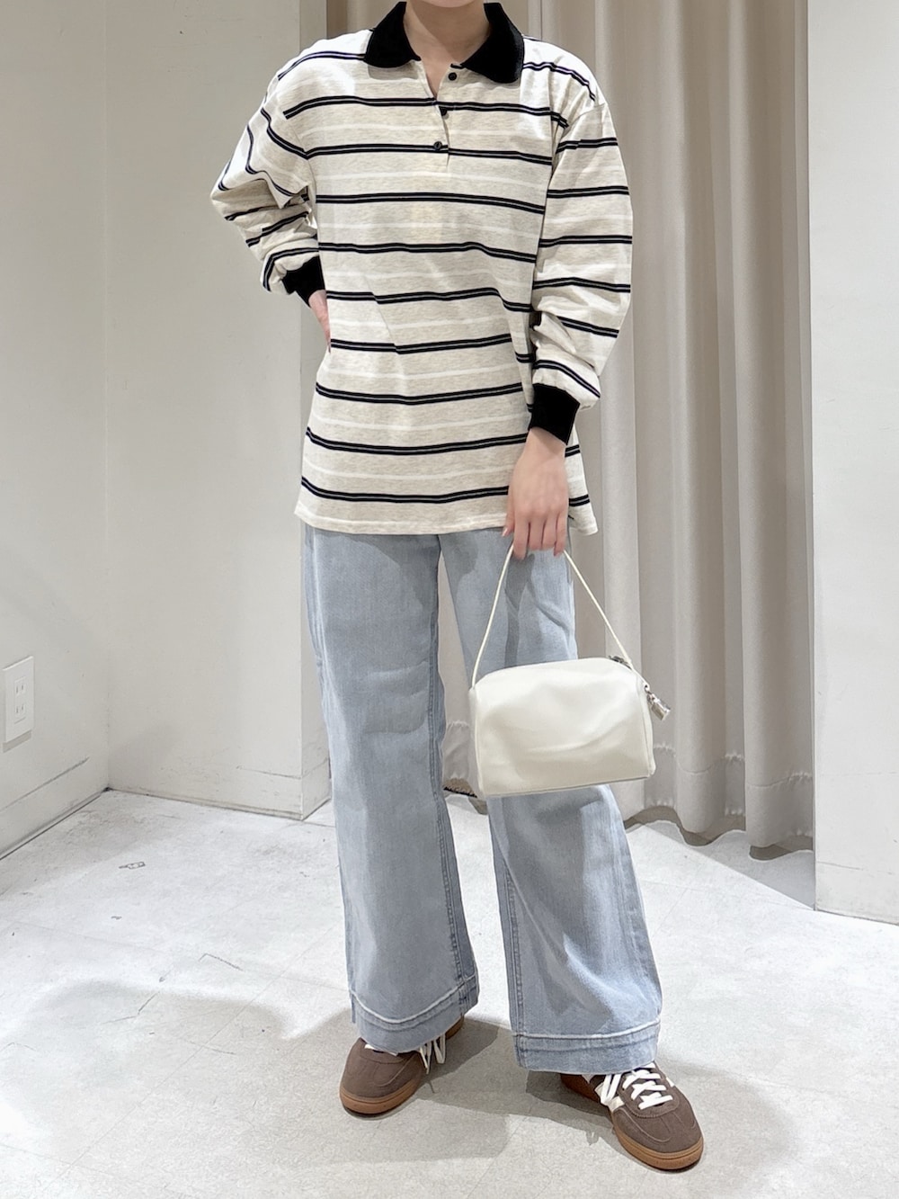 グレー系のTシャツ/カットソー、ホワイト系のハンドバッグ、ブルー系のデニムパンツを着用したレディースの春コーディネートの2枚目の写真