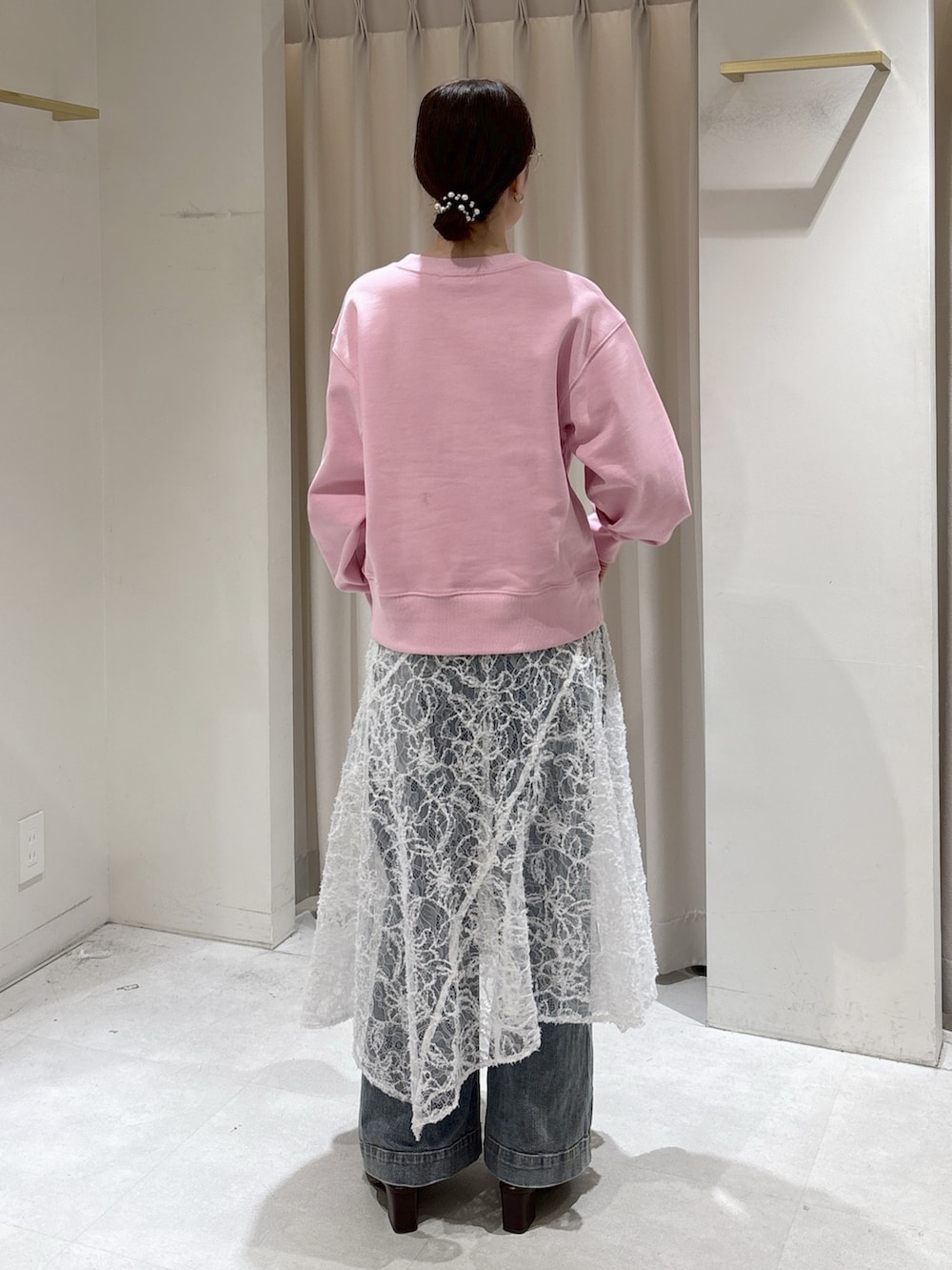 ピンク系のスウェット、ホワイト系のスカート、ブルー系のデニムパンツを着用したレディースの冬コーディネートの3枚目の写真