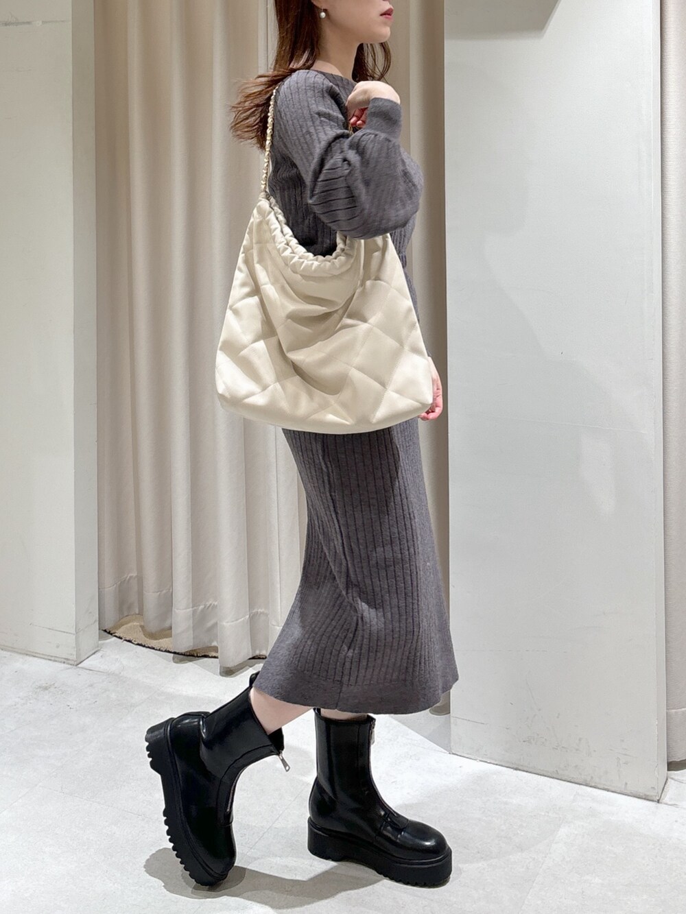 ホワイト系のブルゾン、グレー系のワンピース、ホワイト系のトートバッグを着用したレディースの冬コーディネートの8枚目の写真