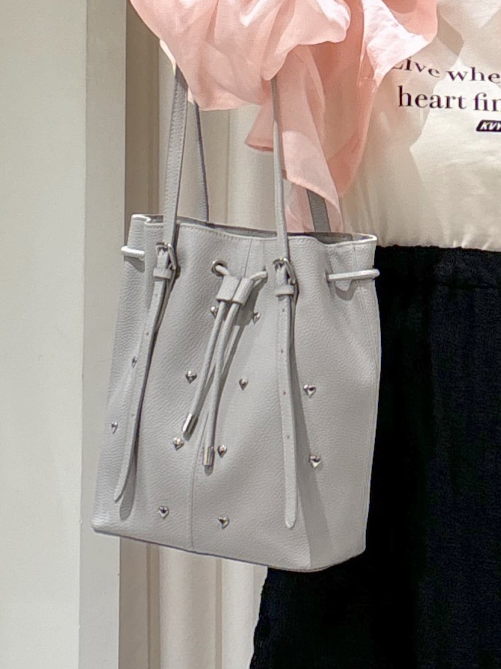 ピンク系のシャツ/ブラウス、ホワイト系のTシャツ/カットソー、グレー系のトートバッグを着用したレディースの春コーディネートの10枚目の写真