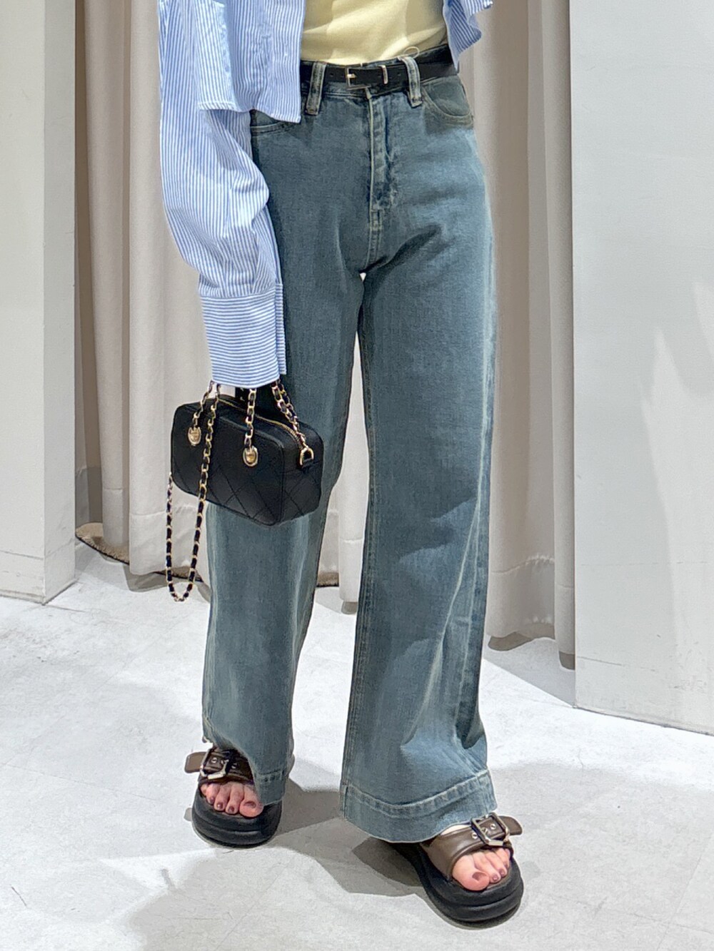 ブルー系のシャツ/ブラウス、イエロー系のタンクトップ、ブラック系のショルダーバッグを着用したレディースの夏コーディネートの7枚目の写真