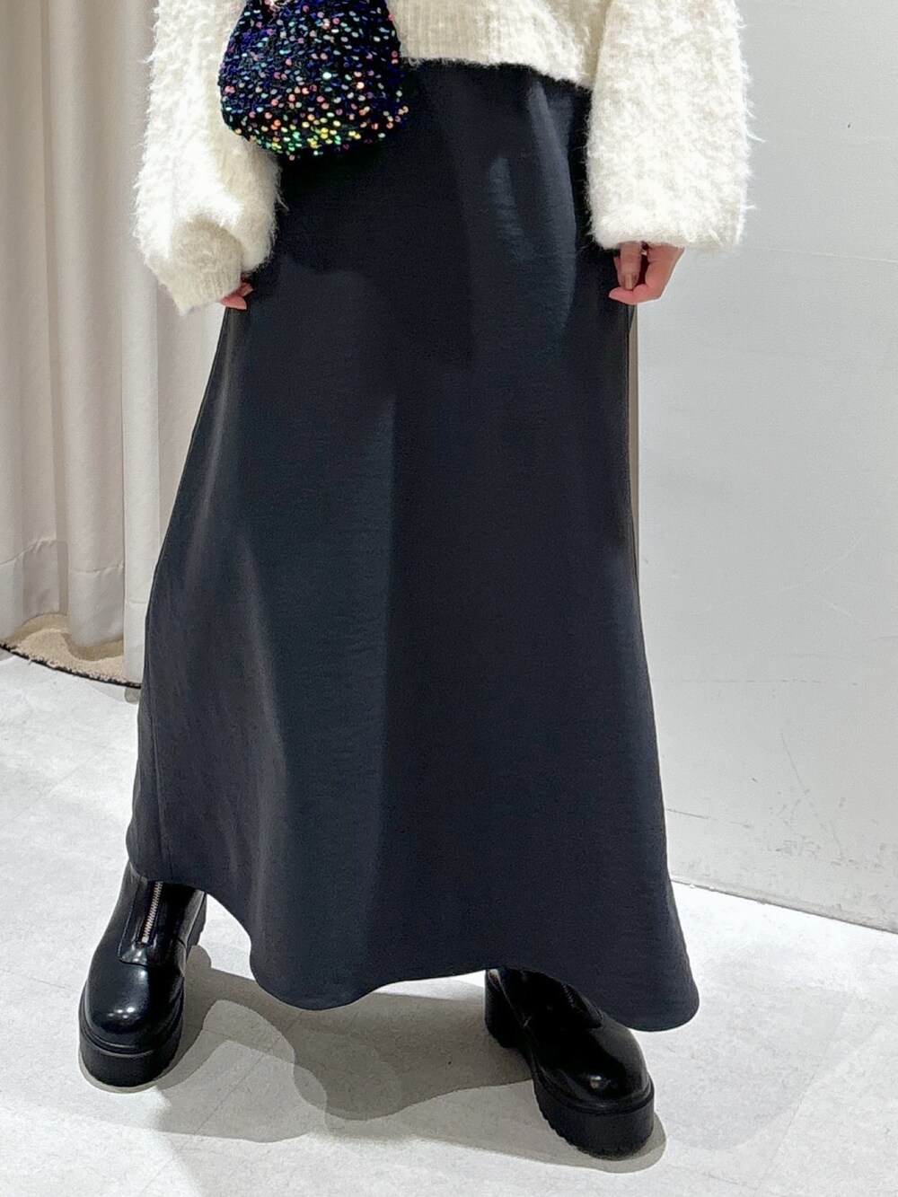 ブラック系のショルダーバッグ、グレー系のスカート、ブラック系のブーツを着用したレディースの冬コーディネートの7枚目の写真