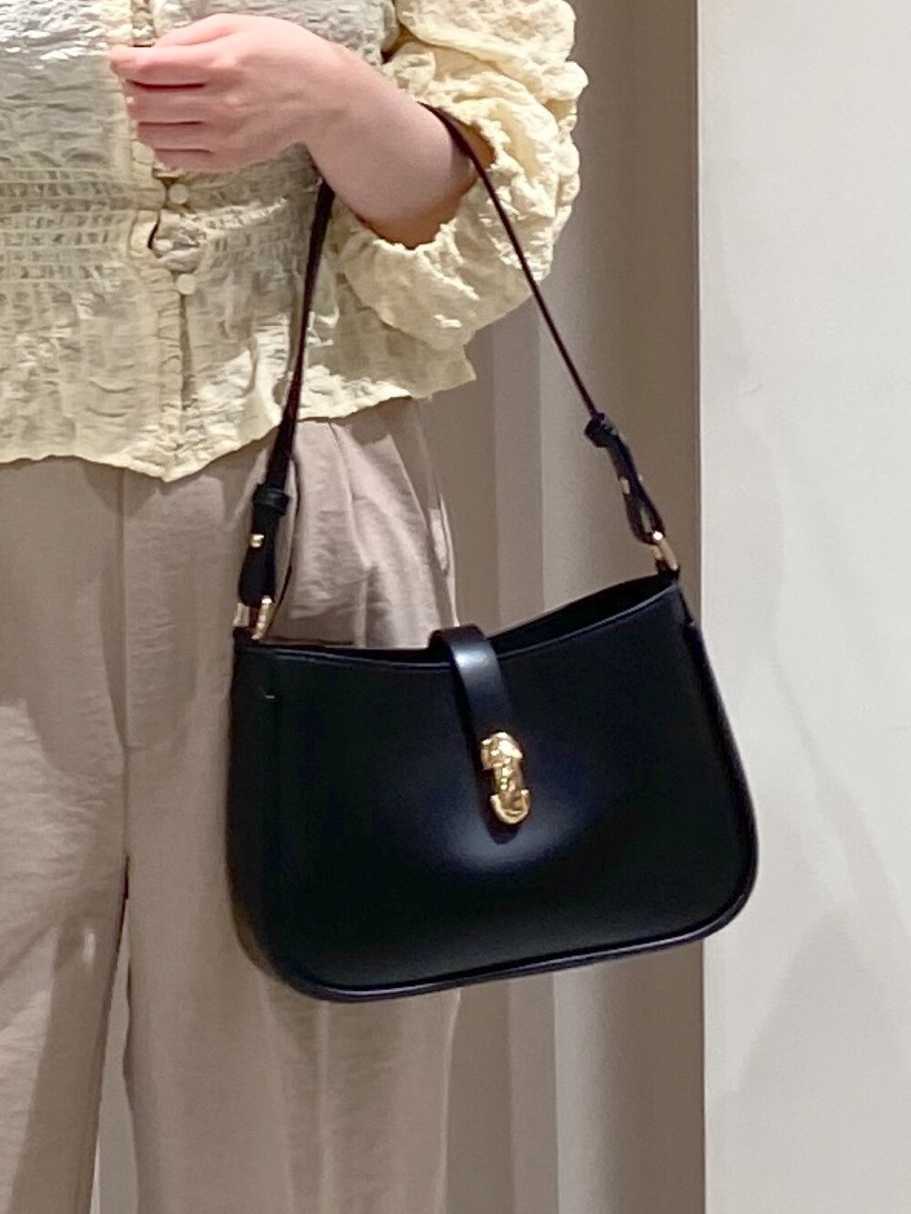 ベージュ系のテーラードジャケット、ホワイト系のスラックス、ホワイト系のカーディガン/ボレロを着用したレディースの春コーディネートの6枚目の写真