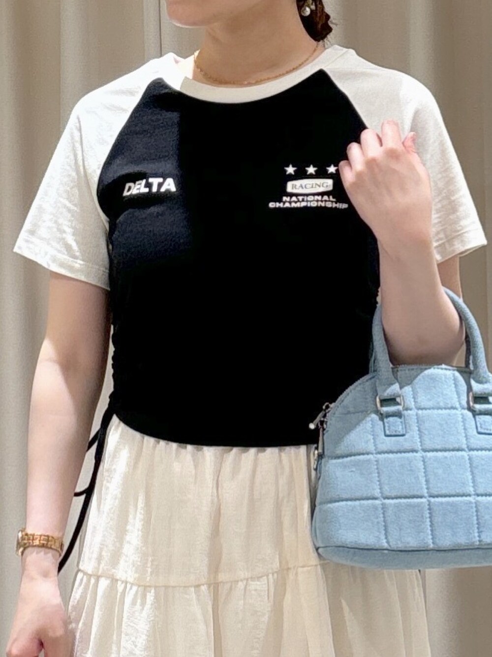 ブラック系のTシャツ/カットソー、ブルー系のトートバッグ、ホワイト系のスカートを着用したレディースの夏コーディネートの3枚目の写真