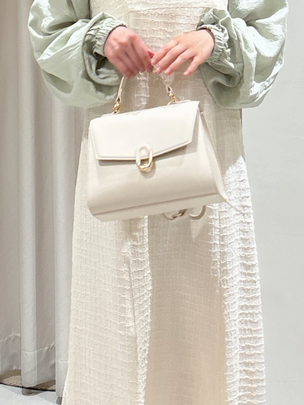 ホワイト系のワンピース、グリーン系のカーディガン/ボレロ、ホワイト系のショルダーバッグを着用したレディースの夏コーディネートの6枚目の写真