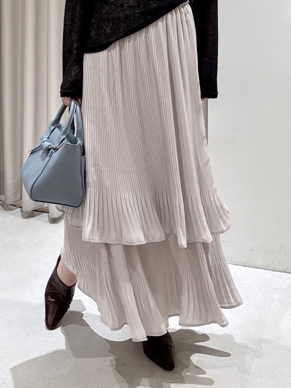 ブラック系のTシャツ/カットソー、ブラック系のキャミソール、ブルー系のハンドバッグを着用したレディースの冬コーディネートの4枚目の写真