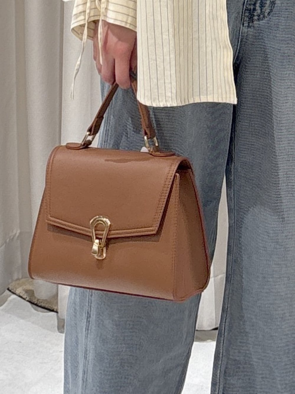 ホワイト系のシャツ/ブラウス、ホワイト系のTシャツ/カットソー、ベージュ系のトートバッグを着用したレディースの冬コーディネートの6枚目の写真