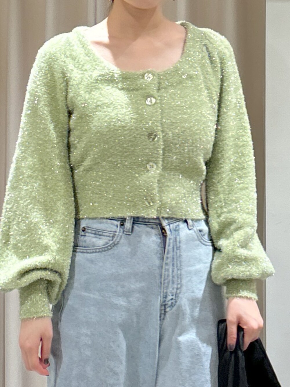 グリーン系のカーディガン/ボレロ、ブルー系のデニムパンツ、ブラック系のハンドバッグを着用したレディースの秋コーディネートの4枚目の写真