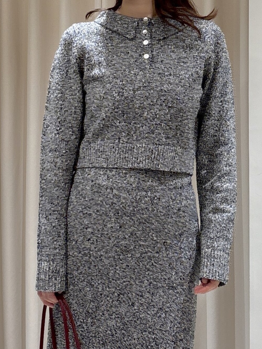 ブラック系のワンピース、レッド系のショルダーバッグ、ブラック系のブーツを着用したレディースの秋コーディネートの4枚目の写真