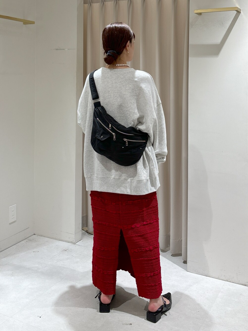 ホワイト系のスウェット、レッド系のスカート、ブラック系のパンプスを着用したレディースの秋コーディネートの6枚目の写真