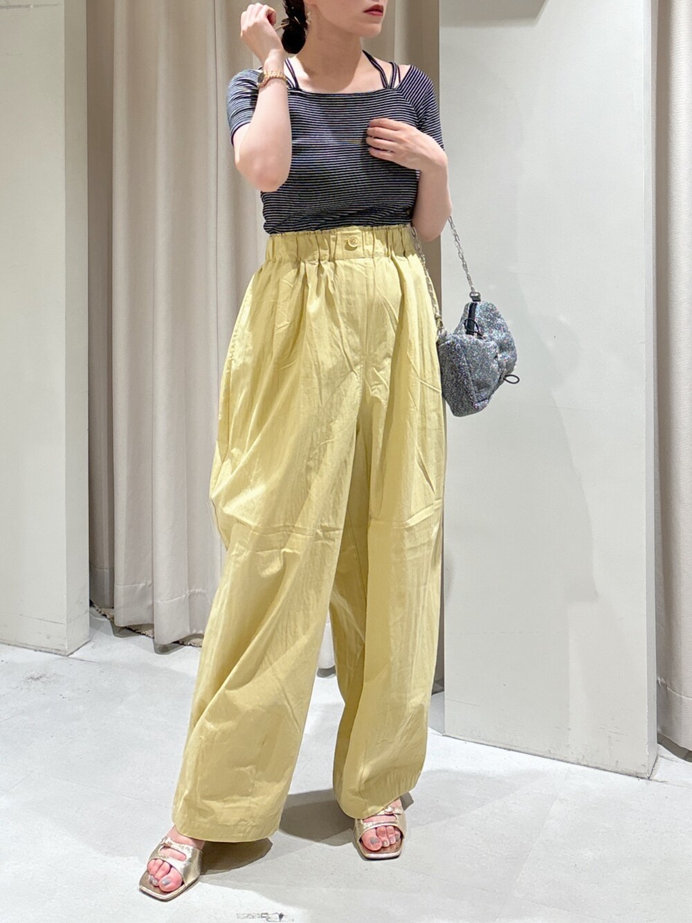 ブラック系のTシャツ/カットソー、イエロー系のその他パンツ、シルバー系のハンドバッグを着用したレディースの夏コーディネートの5枚目の写真