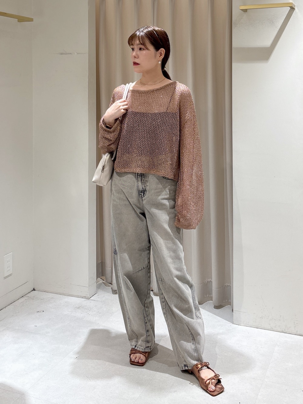 ブラウン系のニット/セーター、ブラック系のキャミソール、グレー系のデニムパンツを着用したレディースの秋コーディネートの2枚目の写真