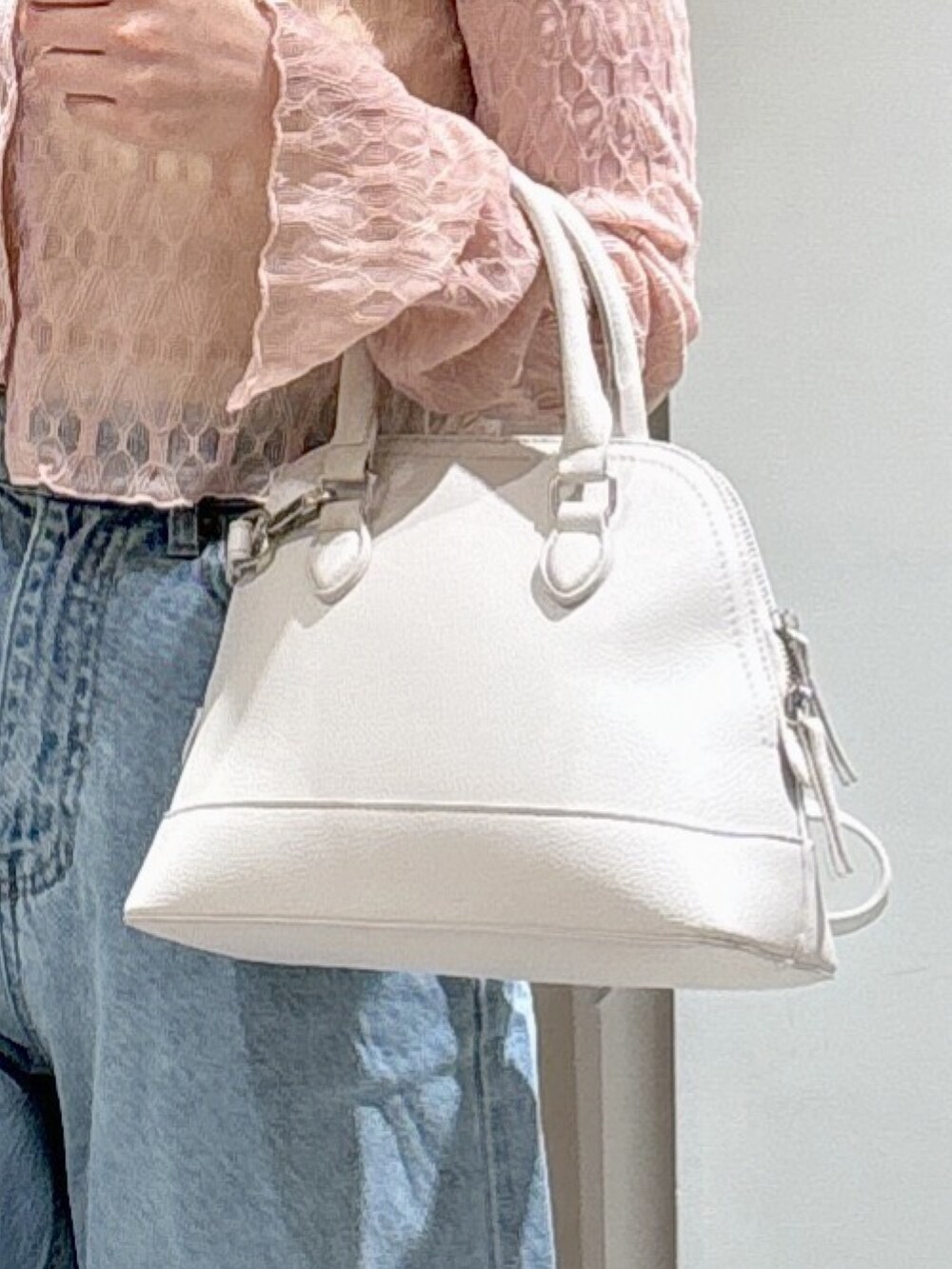 ホワイト系のキャミソール、ピンク系のカーディガン/ボレロ、ホワイト系のショルダーバッグを着用したレディースの春コーディネートの6枚目の写真