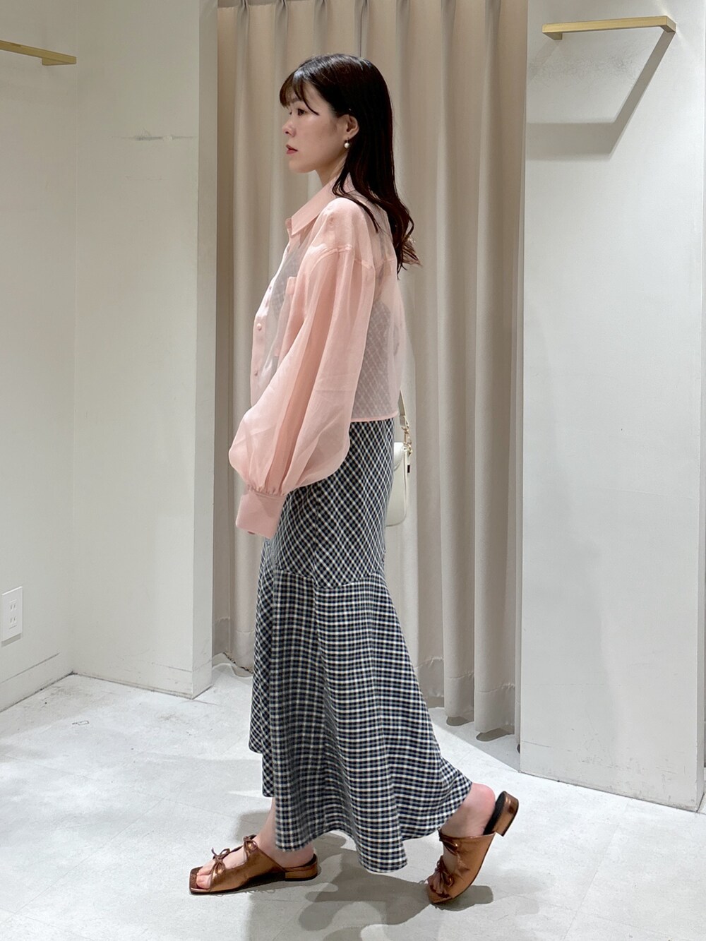 ブラック系のワンピース、ピンク系のシャツ/ブラウス、ブラウン系のサンダルを着用したレディースの春コーディネートの3枚目の写真