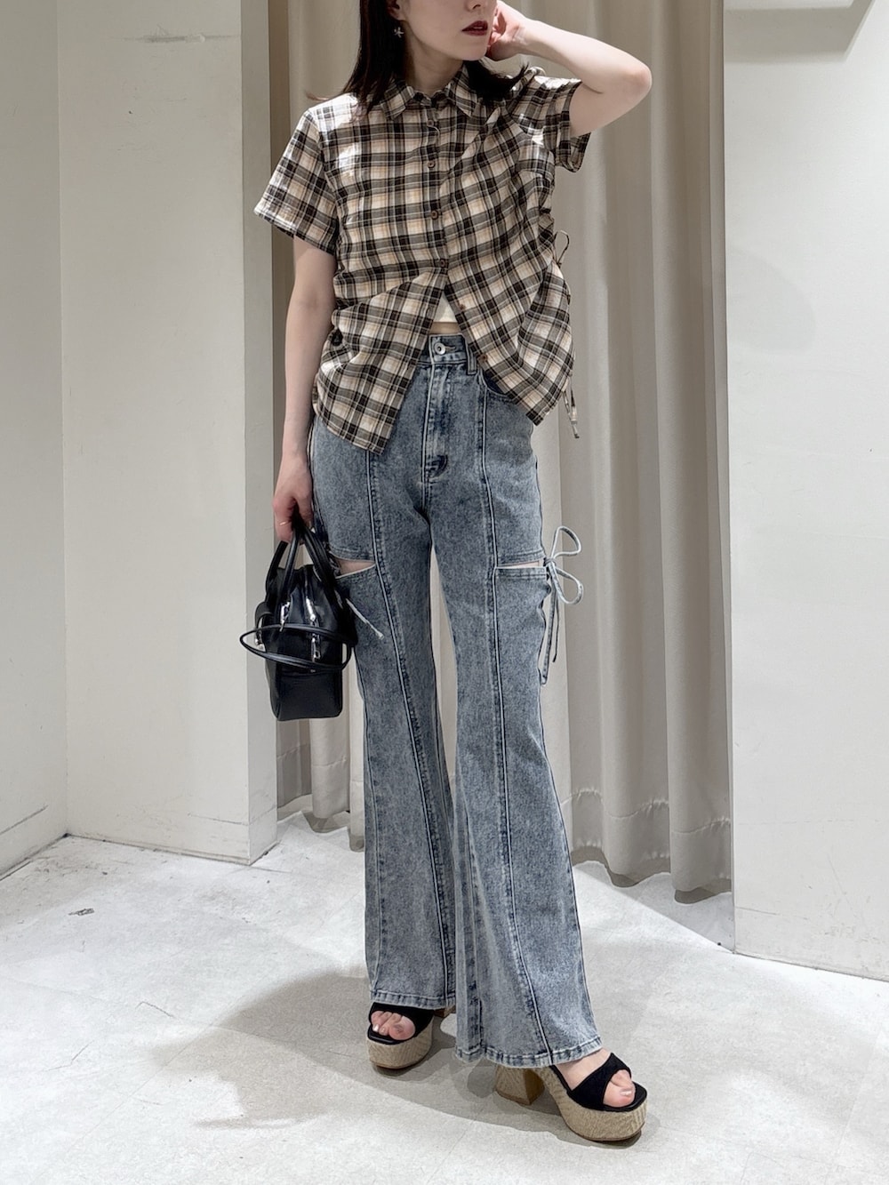 ブラウン系のシャツ/ブラウス、ブルー系のデニムパンツ、ブラック系のハンドバッグを着用したレディースの春コーディネートの4枚目の写真