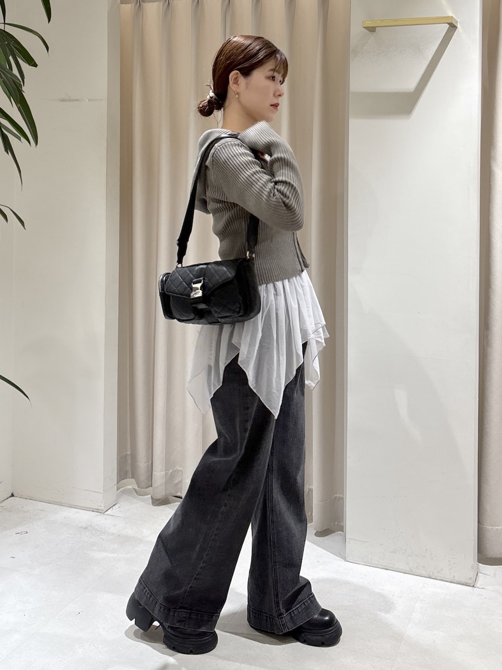 ブラウン系のニット/セーター、グレー系のTシャツ/カットソー、ブラック系のデニムパンツを着用したレディースの秋コーディネートの2枚目の写真