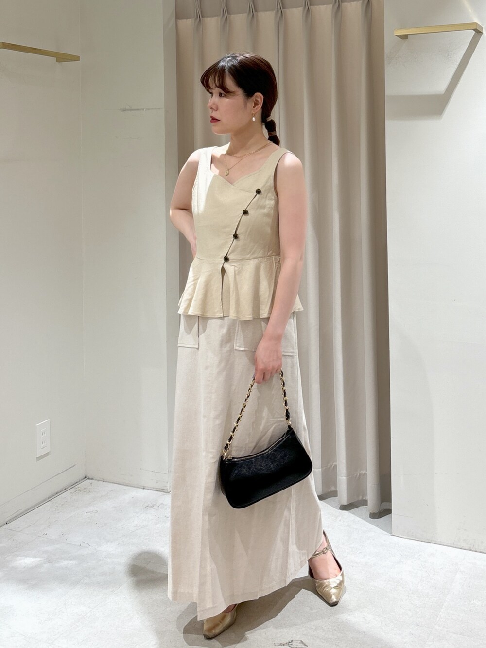 ベージュ系のシャツ/ブラウス、ホワイト系のスカート、ブラック系のトートバッグを着用したレディースの夏コーディネートの2枚目の写真