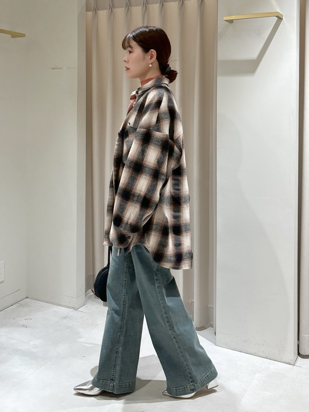 ブラウン系のシャツ/ブラウス、ピンク系のニット/セーター、ブラック系のトートバッグを着用したレディースの冬コーディネートの3枚目の写真