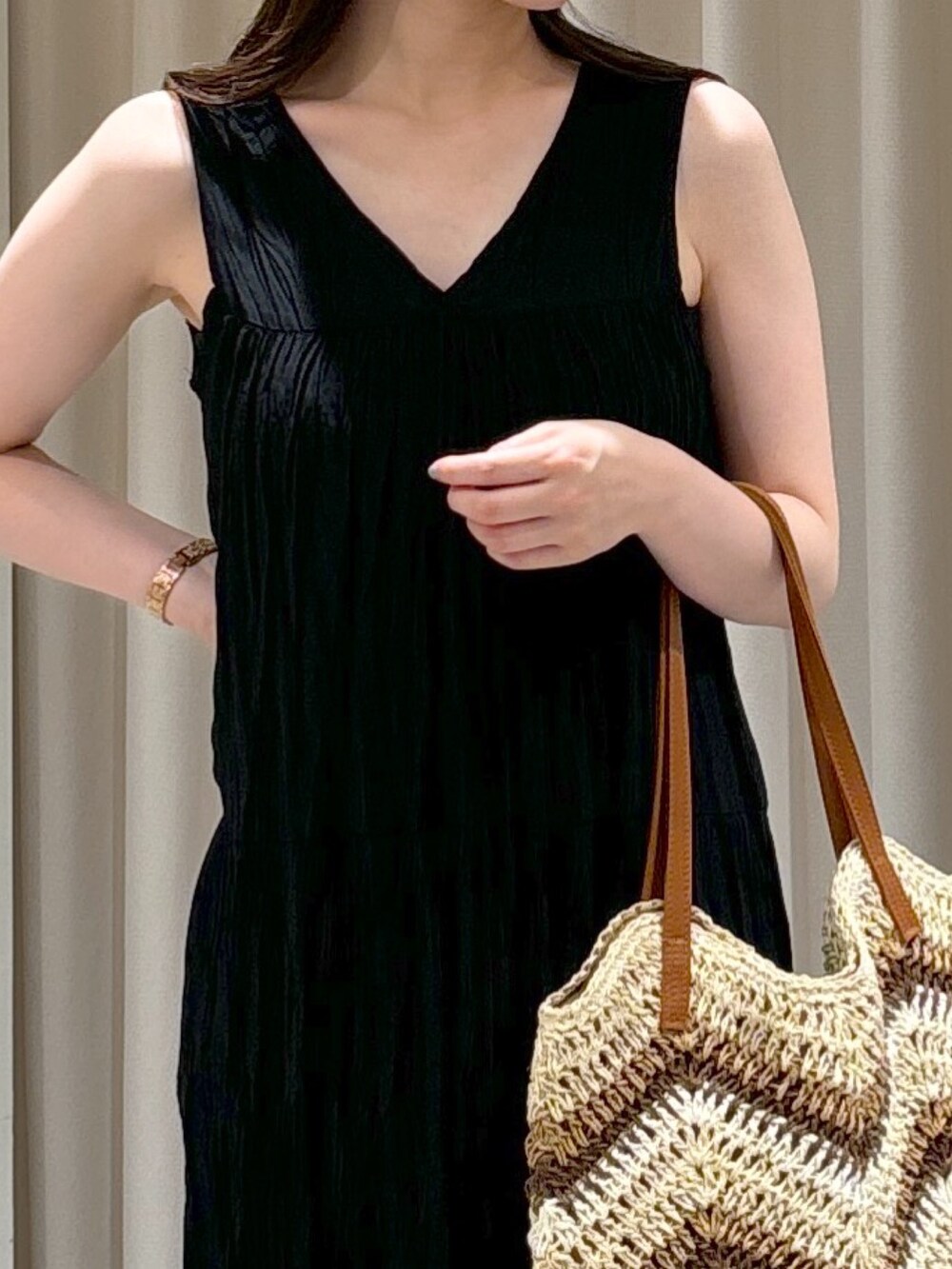 ブラック系のワンピース、ベージュ系のトートバッグ、ゴールド系のサンダルを着用したレディースの夏コーディネートの4枚目の写真