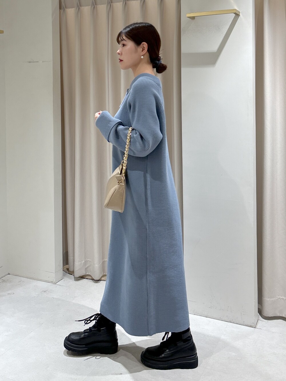 ブルー系のワンピース、ベージュ系のトートバッグ、ブラック系のブーツを着用したレディースの冬コーディネートの3枚目の写真