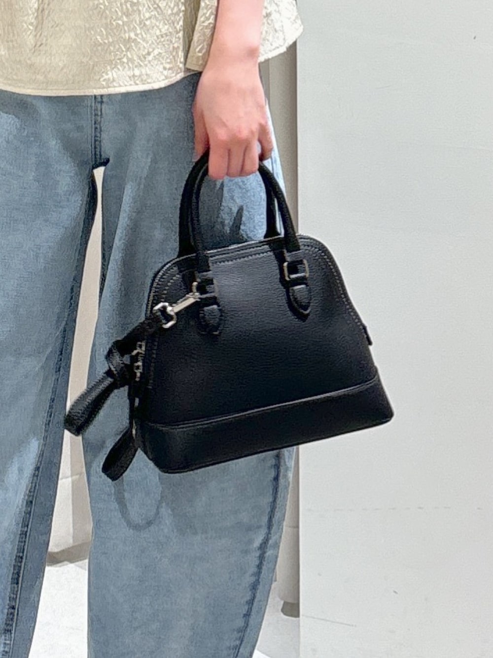 ホワイト系のシャツ/ブラウス、ブラック系のショルダーバッグ、ブルー系のデニムパンツを着用したレディースの夏コーディネートの7枚目の写真