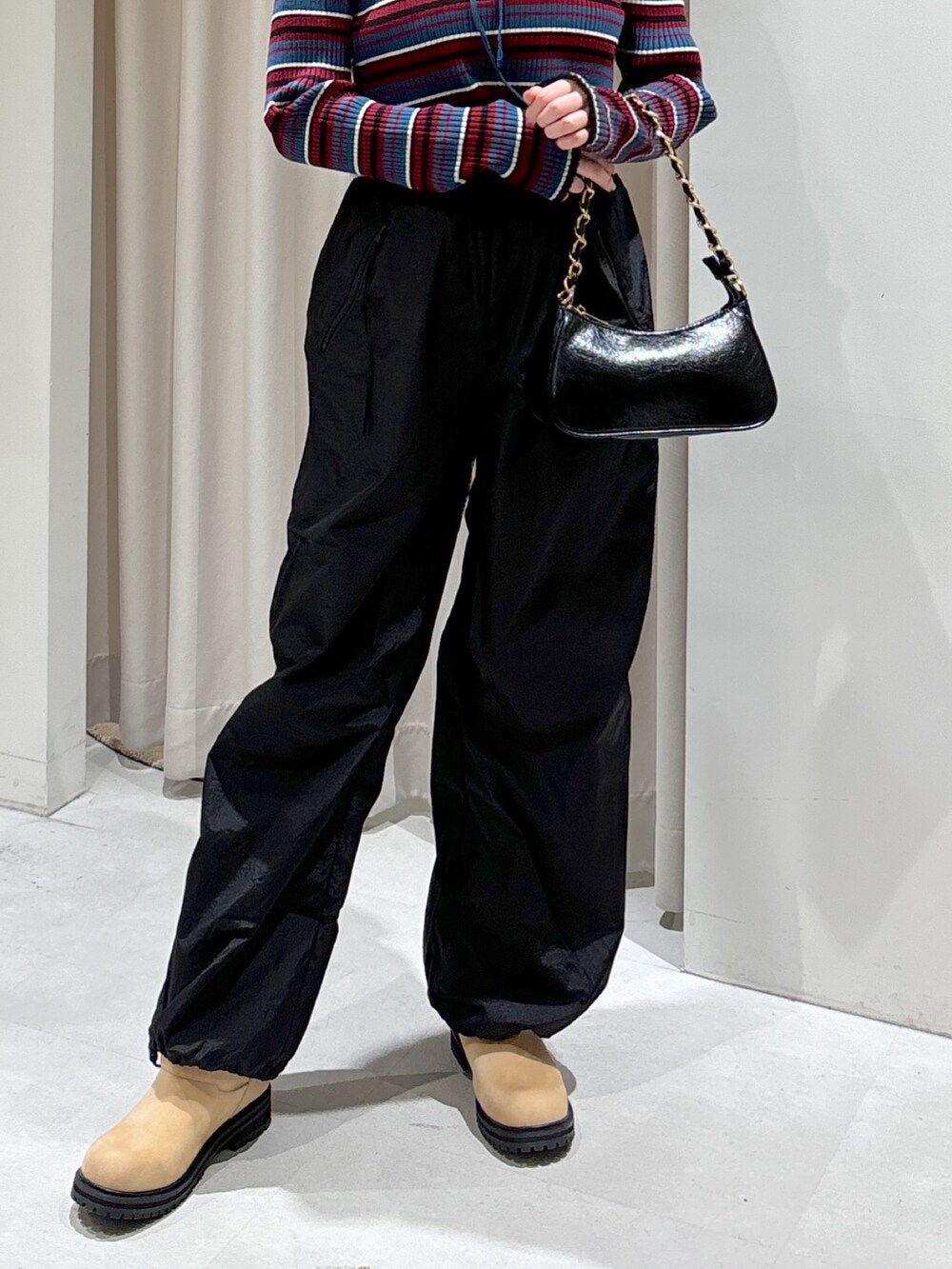 ブルー系のニット/セーター、ブラック系のトートバッグ、ベージュ系のブーツを着用したレディースの秋コーディネートの4枚目の写真