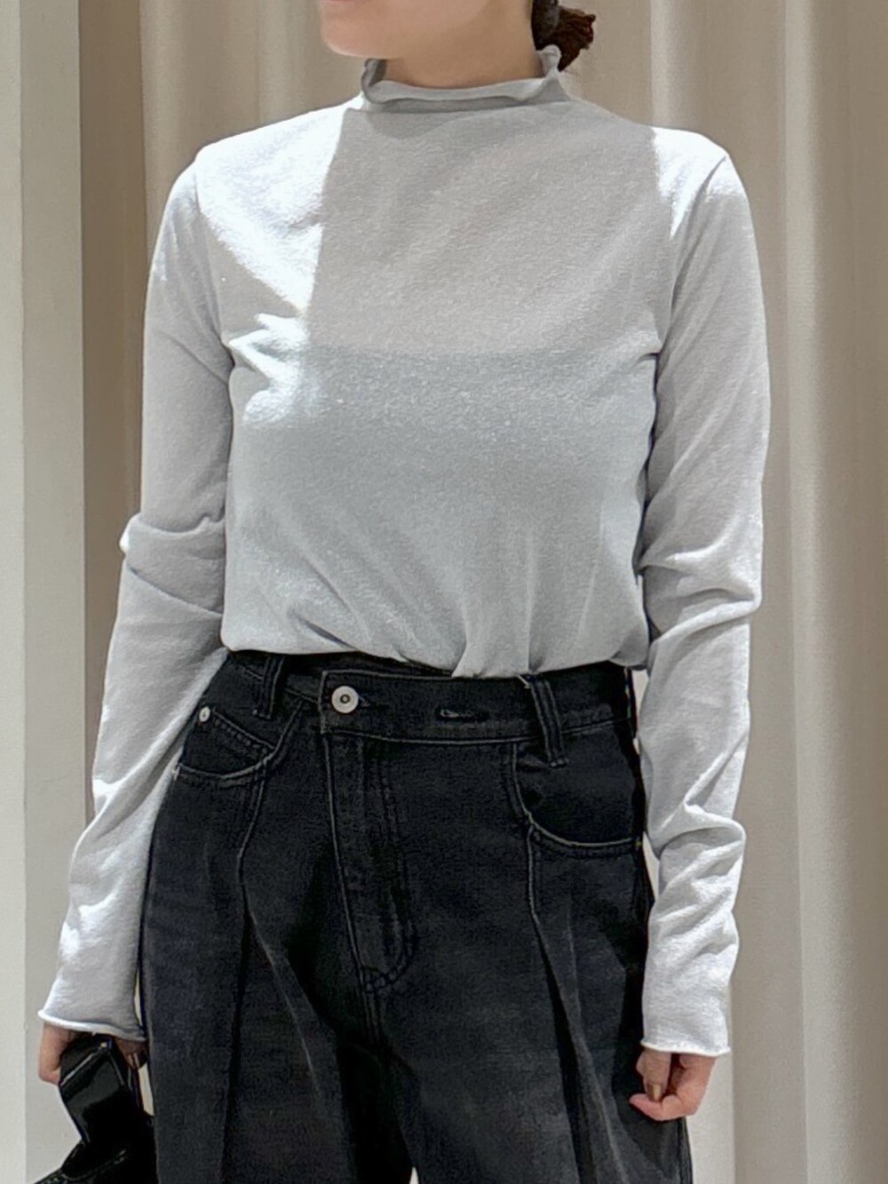 グリーン系のニット/セーター、グレー系のTシャツ/カットソー、ブラック系のハンドバッグを着用したレディースの秋コーディネートの6枚目の写真