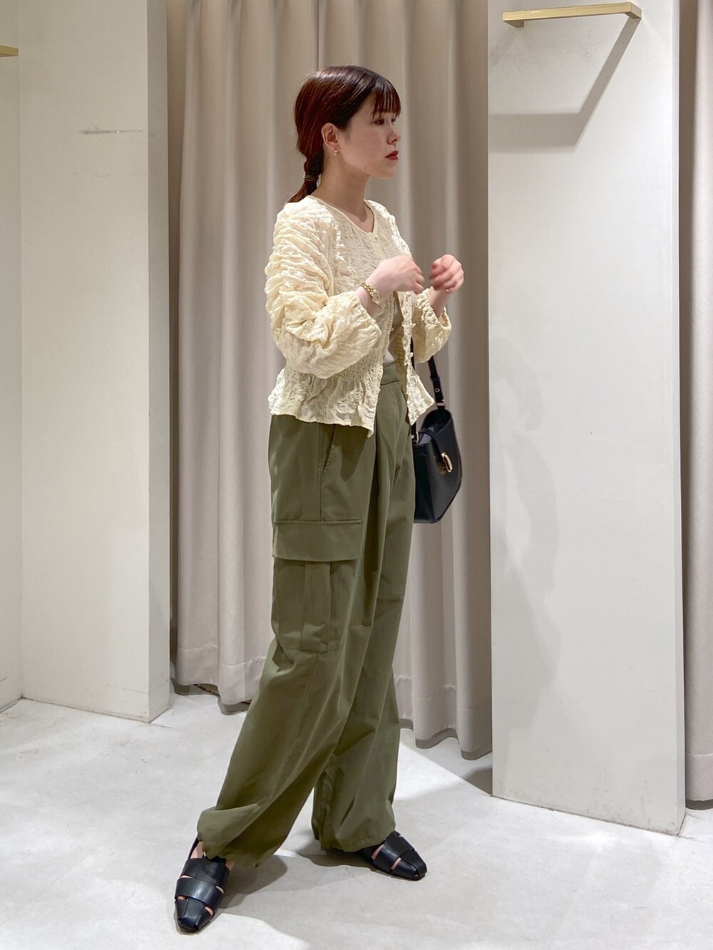 ホワイト系のカーディガン/ボレロ、グレー系のキャミソール、ブラック系のショルダーバッグを着用したレディースの春コーディネートの4枚目の写真