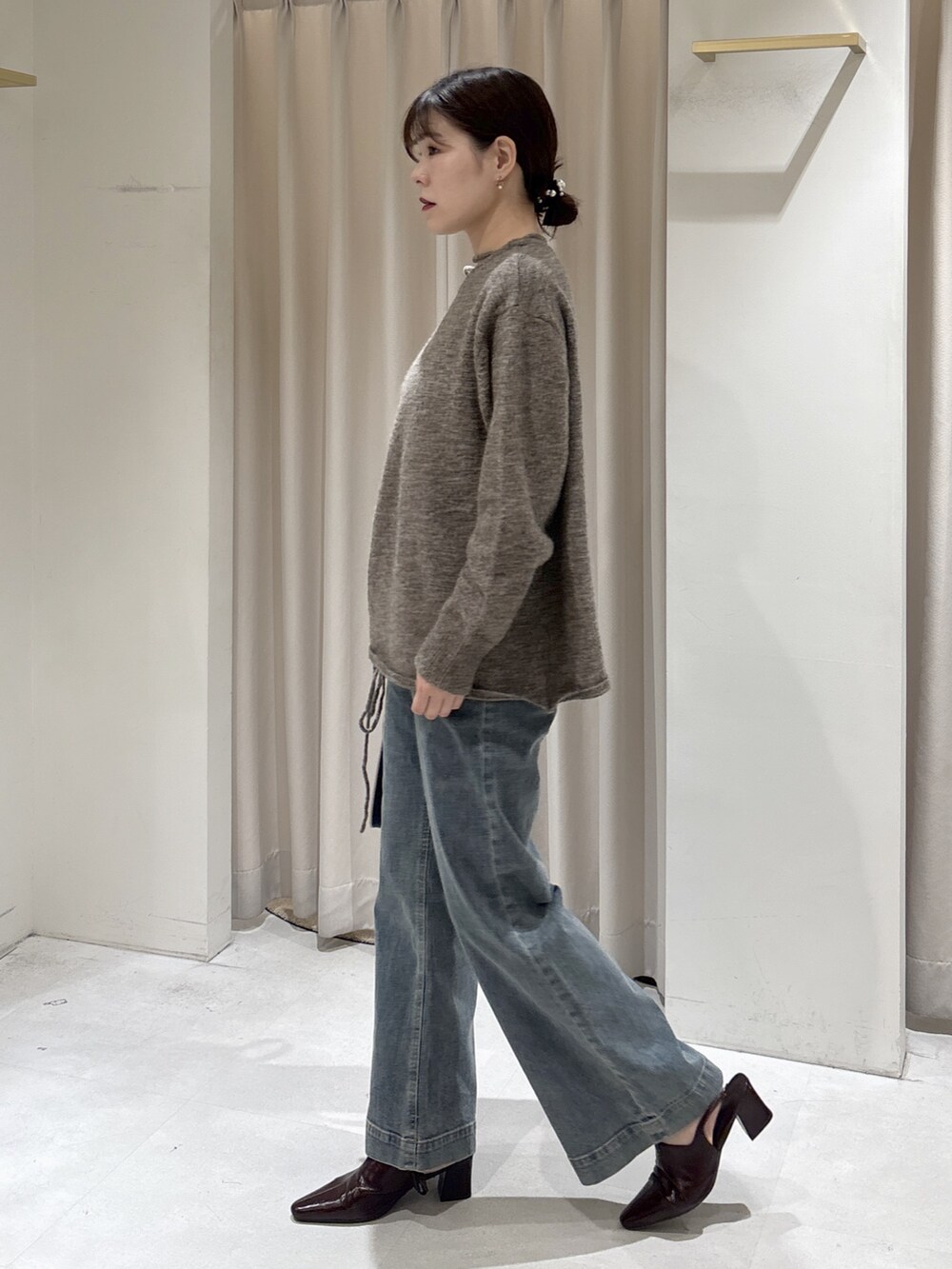 ブラウン系のニット/セーター、ブルー系のデニムパンツ、ブラック系のトートバッグを着用したレディースの冬コーディネートの3枚目の写真