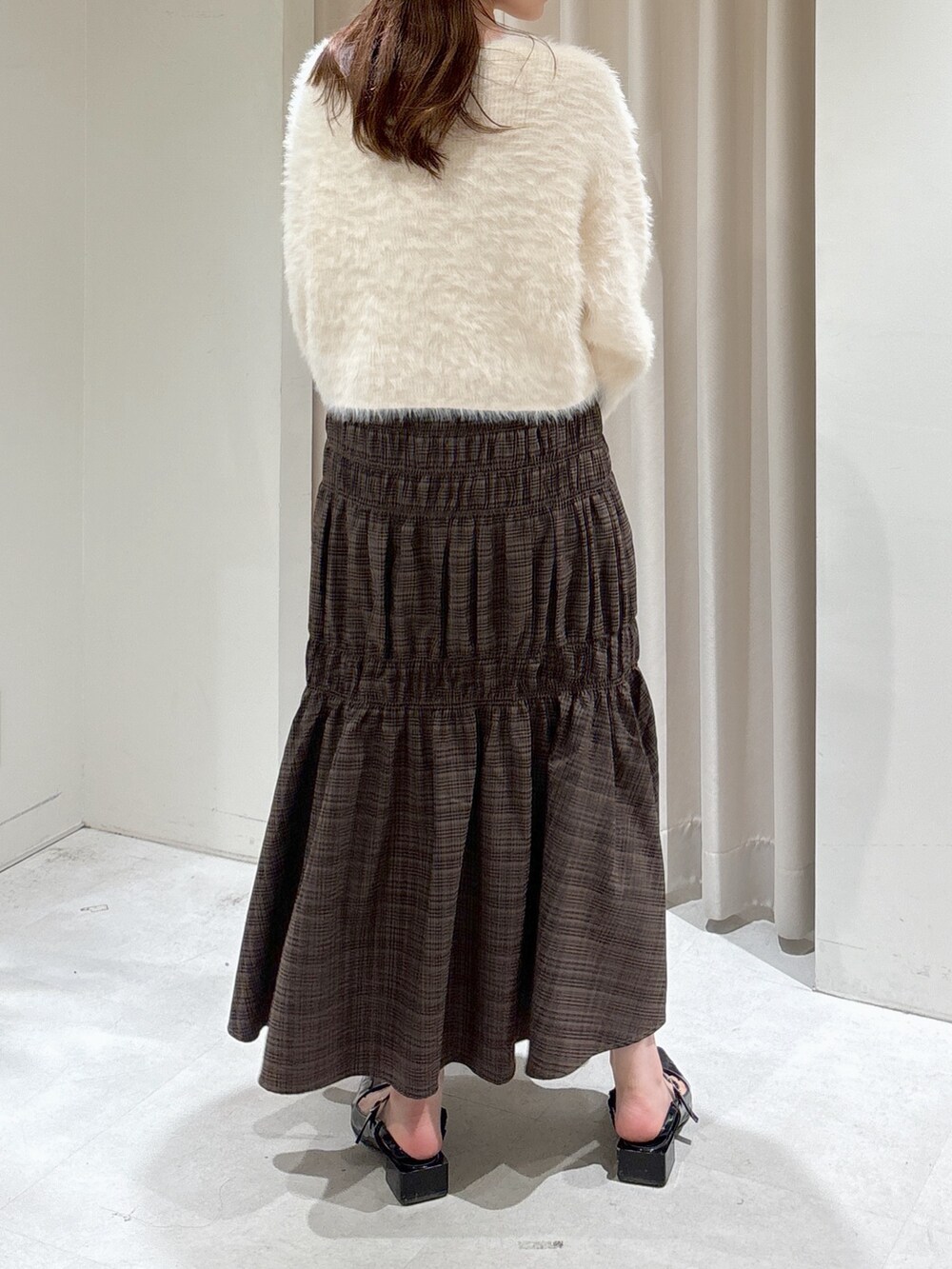 ホワイト系のカーディガン/ボレロ、ブラック系のキャミソール、ブラック系のショルダーバッグを着用したレディースの秋コーディネートの5枚目の写真