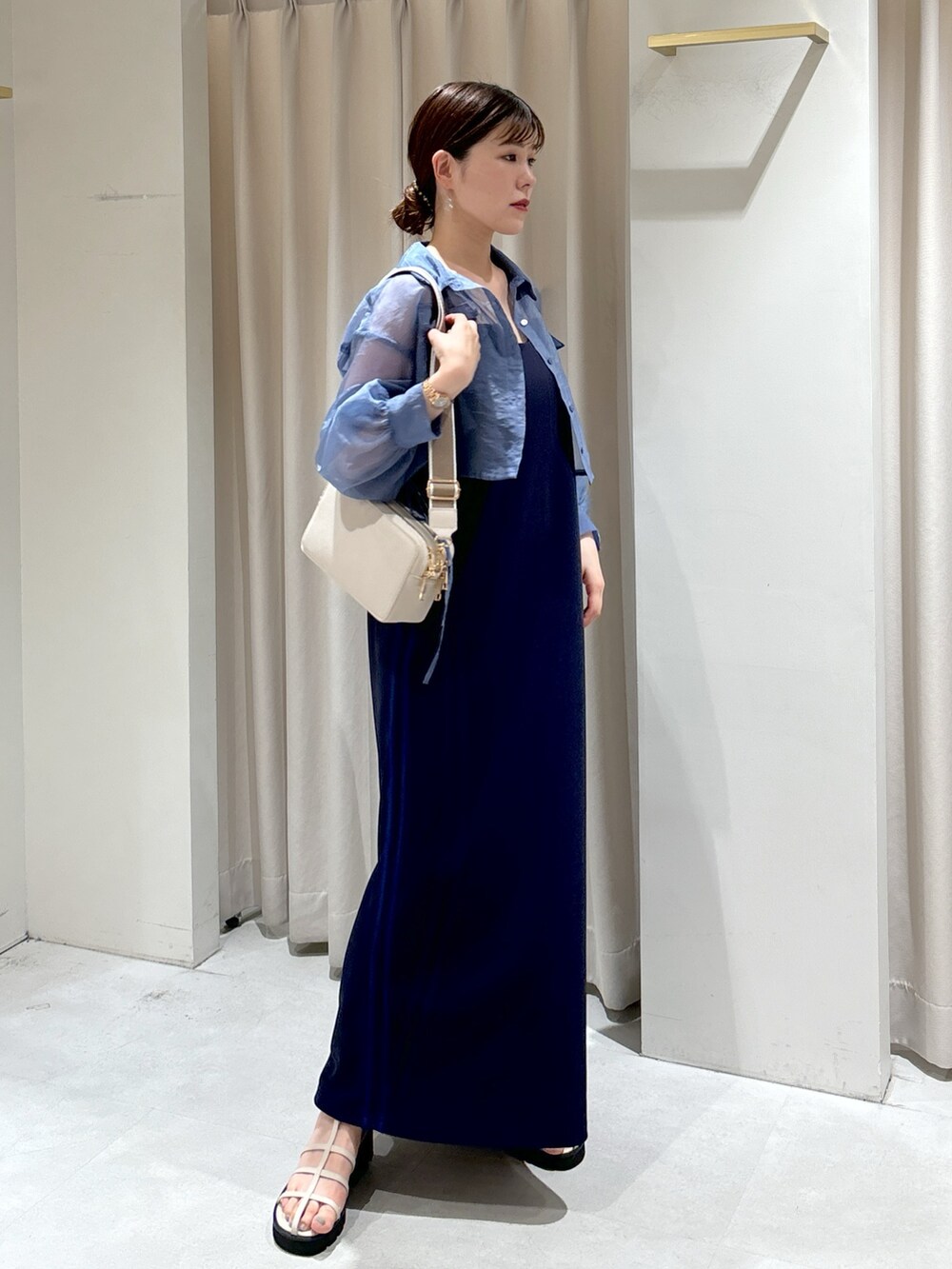 ブルー系のシャツ/ブラウス、ブルー系のワンピース、ホワイト系のボディバッグ/ウエストポーチを着用したレディースの夏コーディネートの2枚目の写真