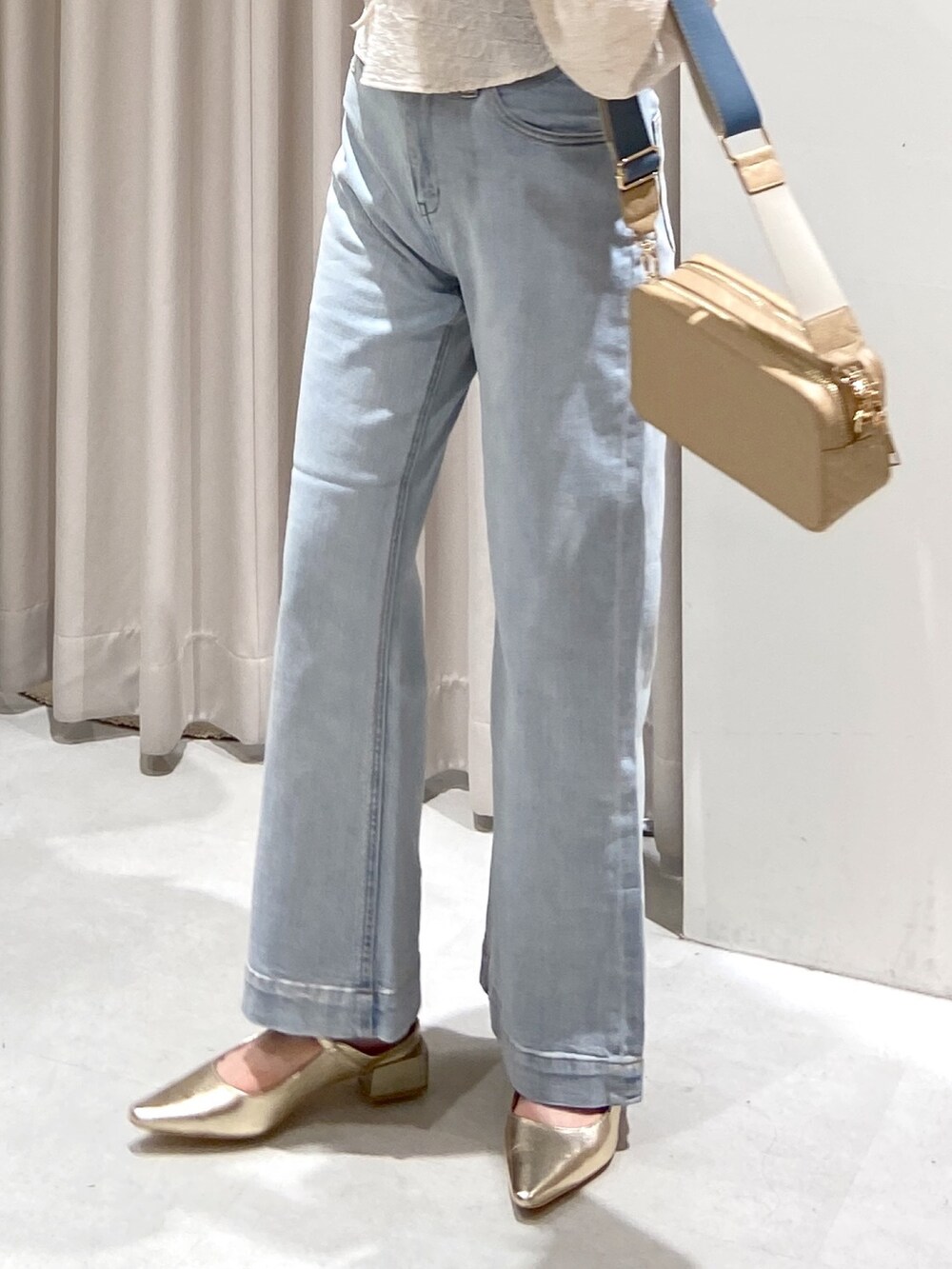 ホワイト系のシャツ/ブラウス、ブルー系のデニムパンツ、ベージュ系のボディバッグ/ウエストポーチを着用したレディースの春コーディネートの3枚目の写真