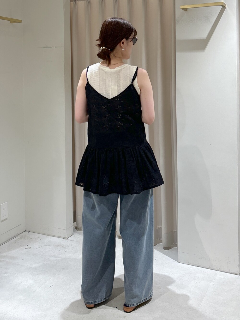 ブラック系のシャツ/ブラウス、ホワイト系のニット/セーター、ベージュ系のトートバッグを着用したレディースの春コーディネートの3枚目の写真