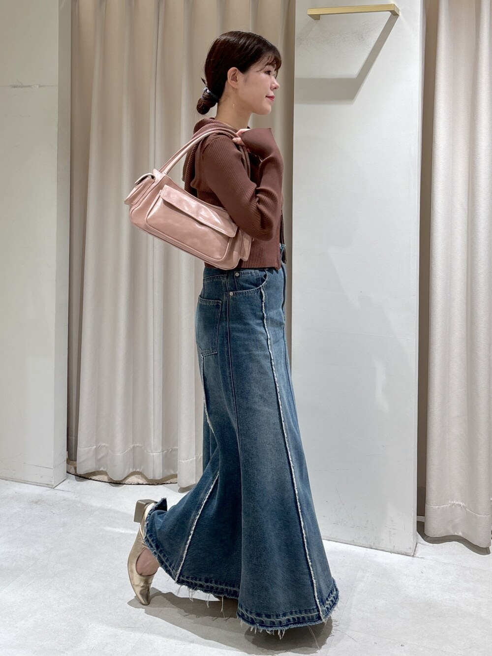 ブラウン系のパーカー、ブラック系のキャミソール、ピンク系のショルダーバッグを着用したレディースの春コーディネートの2枚目の写真