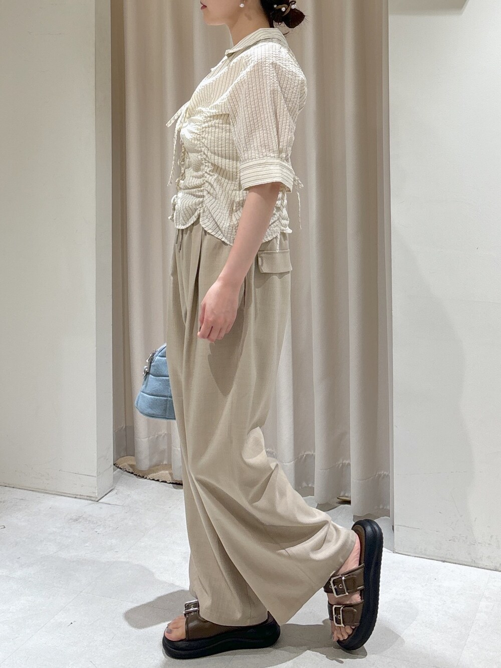 ベージュ系のその他パンツ、ブルー系のトートバッグ、ブラウン系のサンダルを着用したレディースの夏コーディネートの5枚目の写真