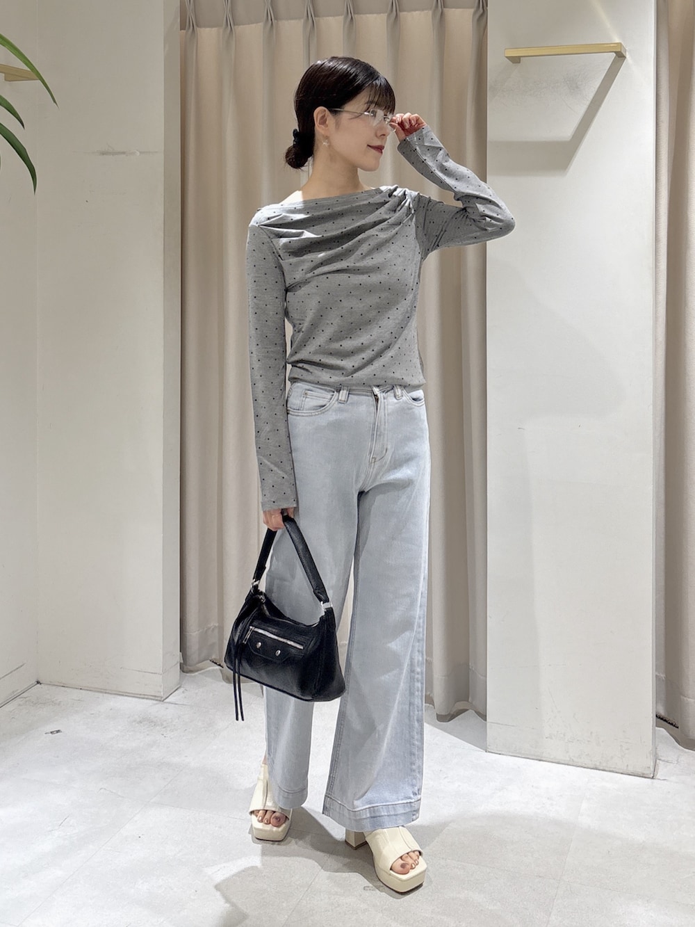 ブルー系のデニムパンツ、ブラック系のショルダーバッグ、ホワイト系のサンダルを着用したレディースの夏コーディネートの2枚目の写真