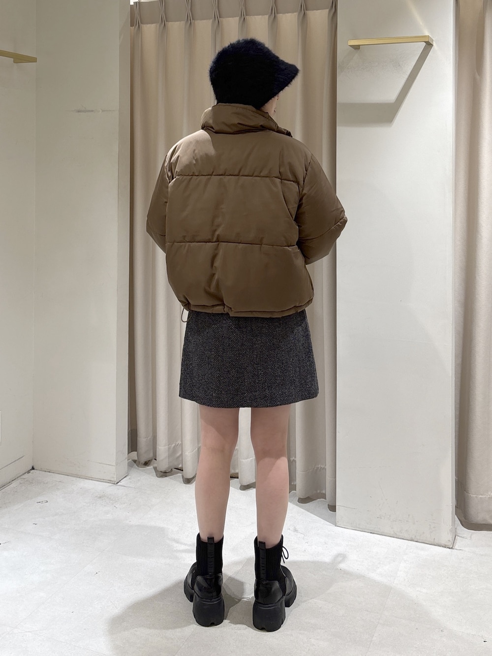 ブラウン系のブルゾン、ブラック系のスカート、ホワイト系のボストンバッグを着用したレディースの冬コーディネートの5枚目の写真