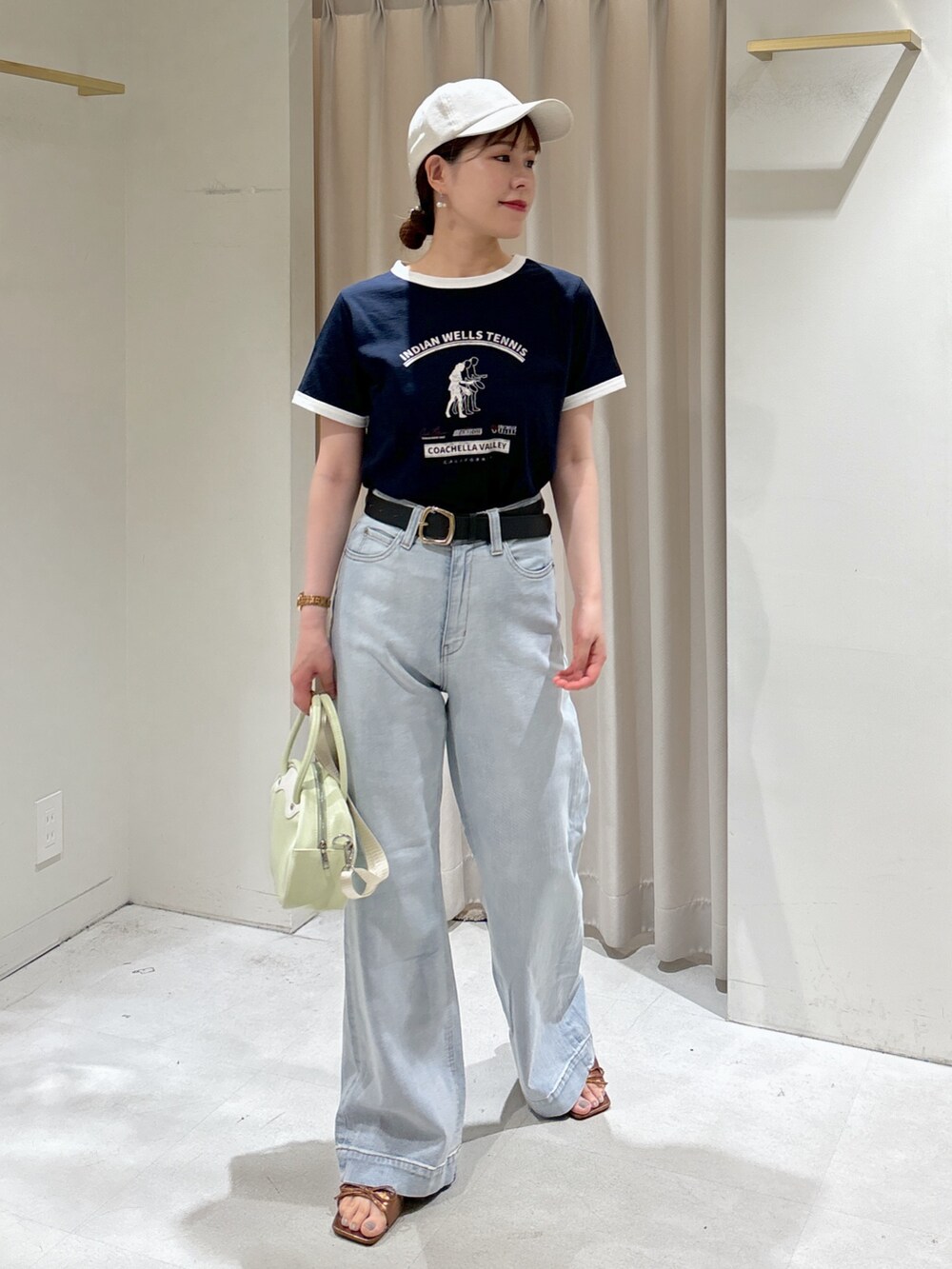 ブルー系のTシャツ/カットソー、ブルー系のデニムパンツ、グリーン系のトートバッグを着用したレディースの夏コーディネートの2枚目の写真