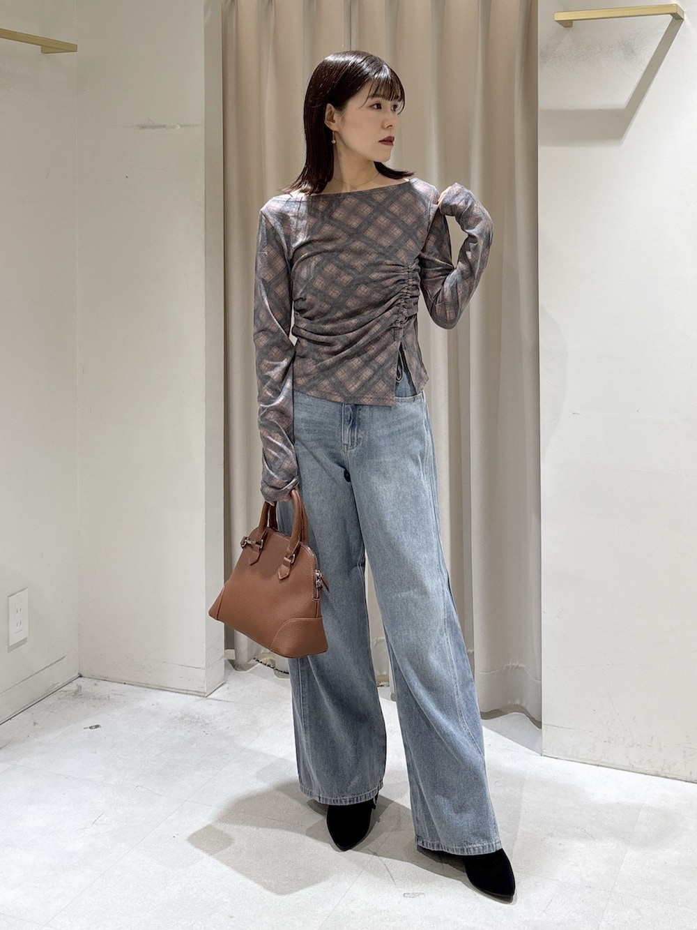 ブラウン系のTシャツ/カットソー、ブルー系のデニムパンツ、ブラウン系のショルダーバッグを着用したレディースの秋コーディネートの7枚目の写真