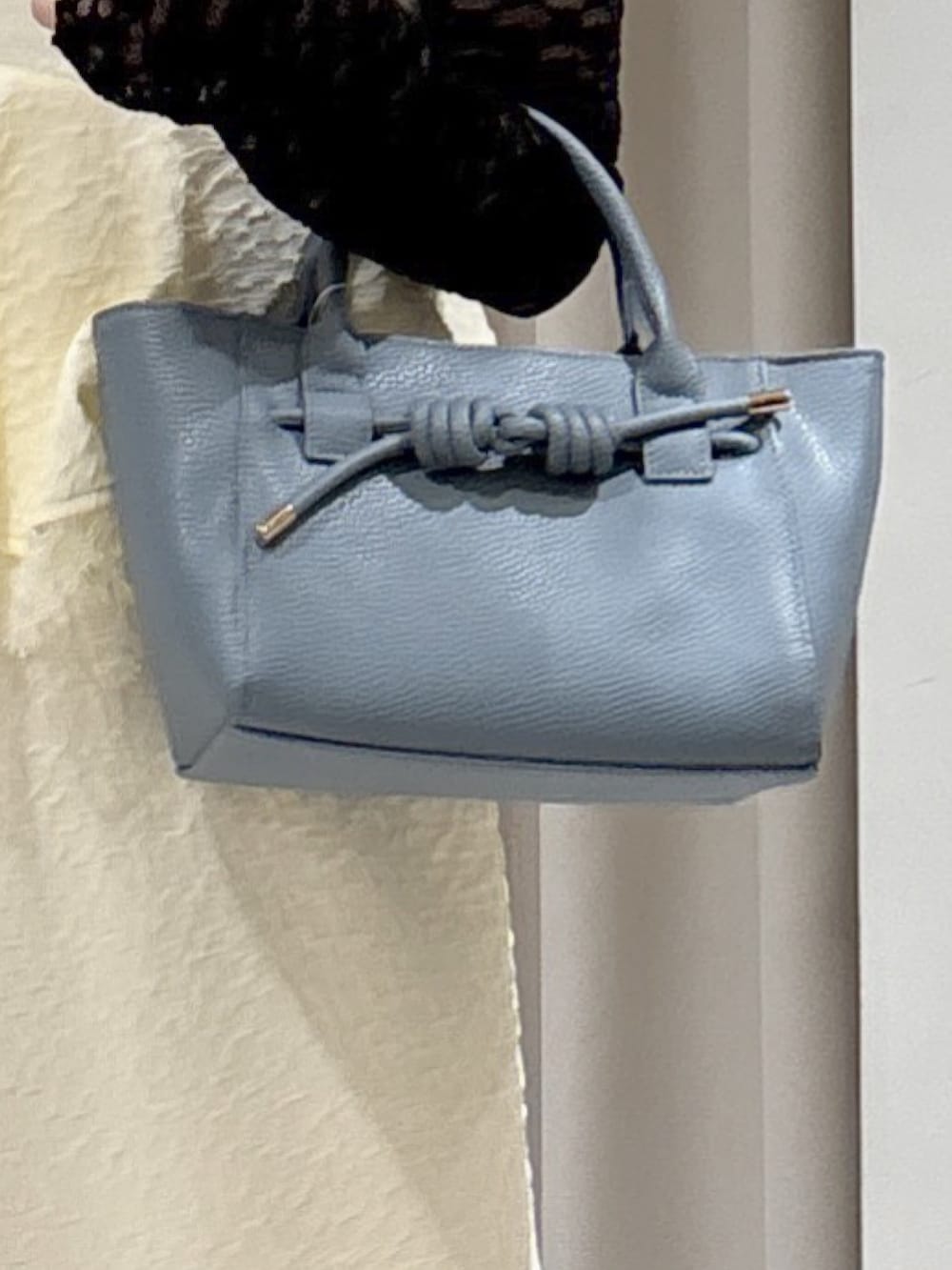 ホワイト系のワンピース、ブラック系のTシャツ/カットソー、ブルー系のハンドバッグを着用したレディースの冬コーディネートの4枚目の写真