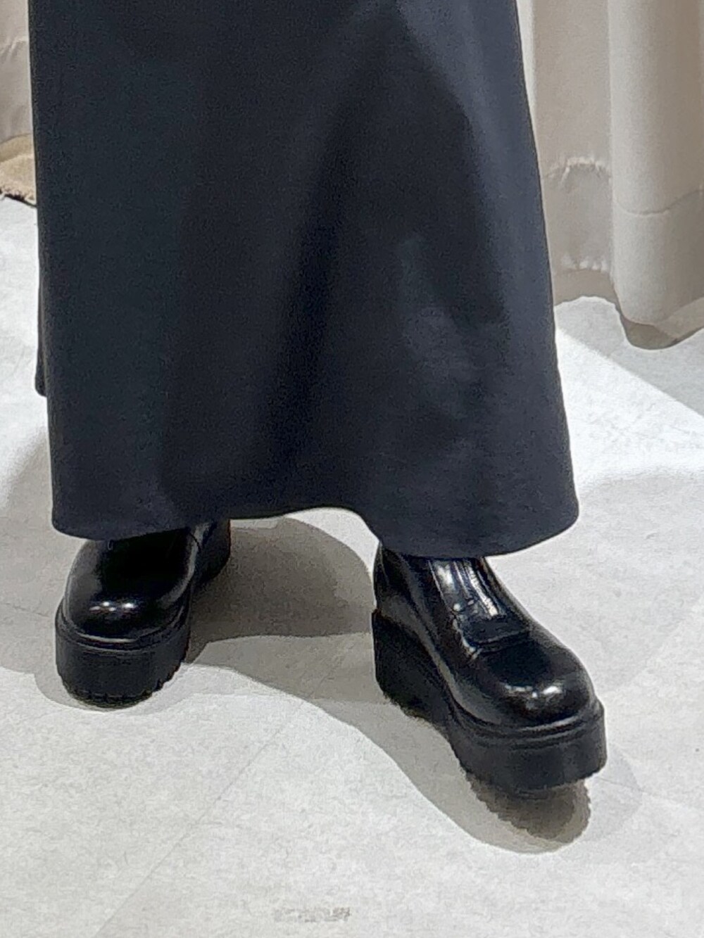 ブラック系のショルダーバッグ、グレー系のスカート、ブラック系のブーツを着用したレディースの冬コーディネートの8枚目の写真