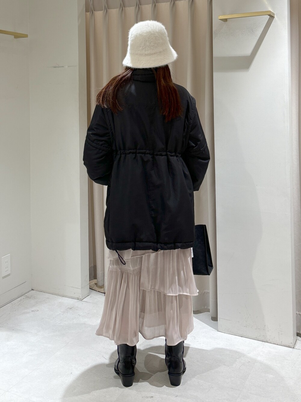 ホワイト系のスカート、ブラック系のその他アウター、ピンク系のニット/セーターを着用したレディースの冬コーディネートの3枚目の写真