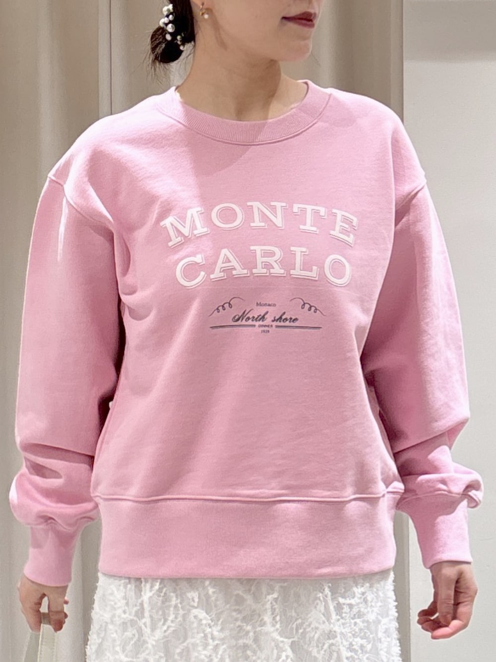 ピンク系のスウェット、ホワイト系のスカート、ホワイト系のハンドバッグを着用したレディースの冬コーディネートの3枚目の写真