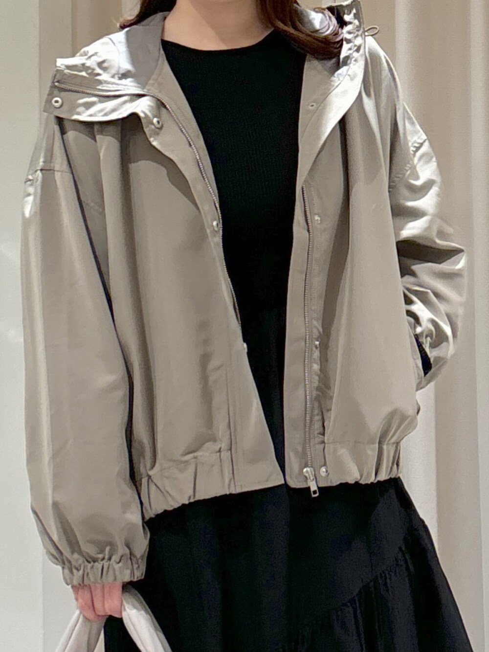 グリーン系のマウンテンパーカー、ブラック系のワンピース、ブラック系のブーツを着用したレディースの冬コーディネートの2枚目の写真